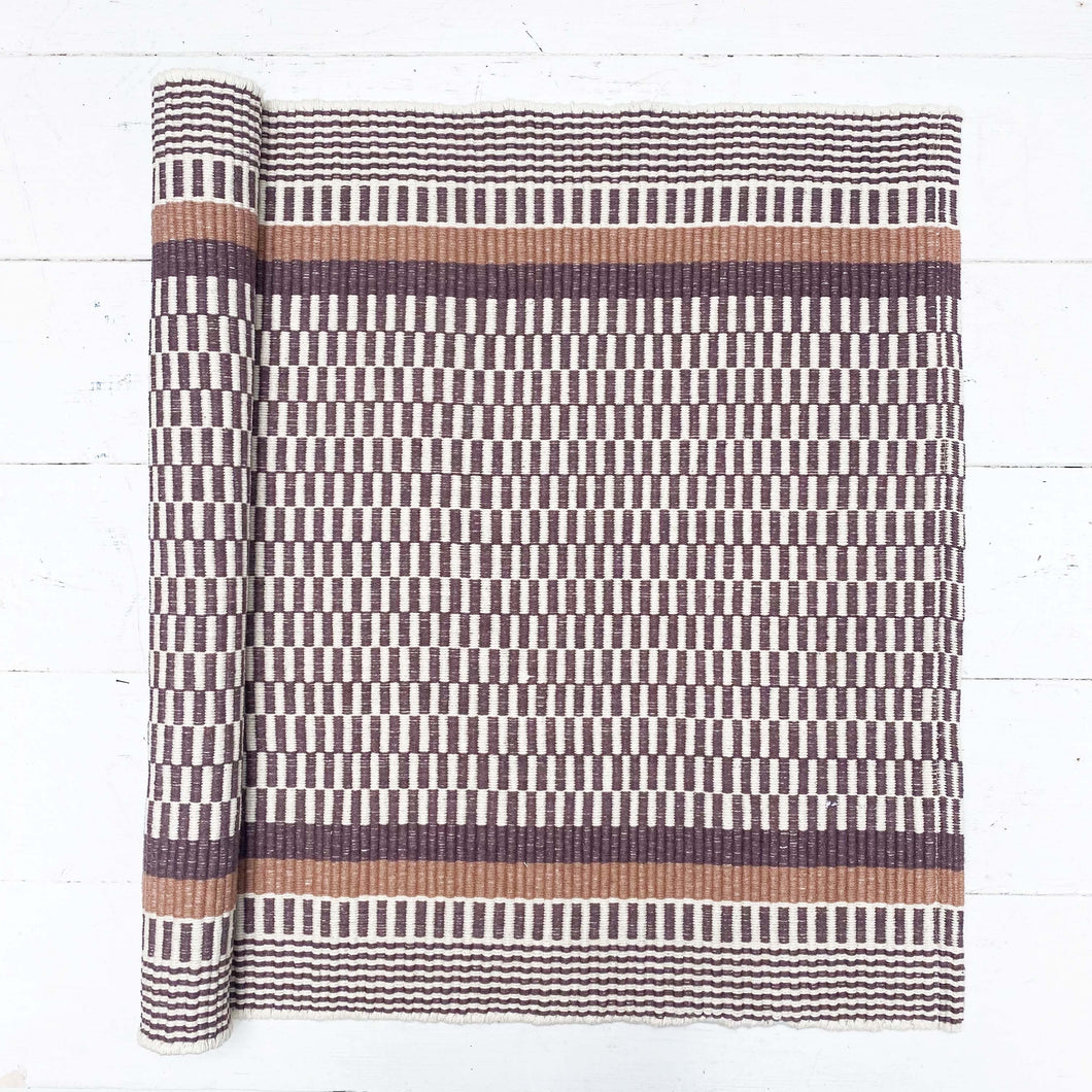 brown and white rug with brown and striped border