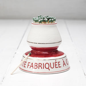white and red ceramic match strike holder with red French lettering