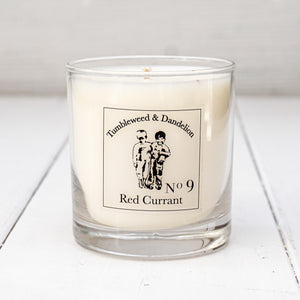Clear glass candle, Tumbleweed and Dandelion logo, red currant scent