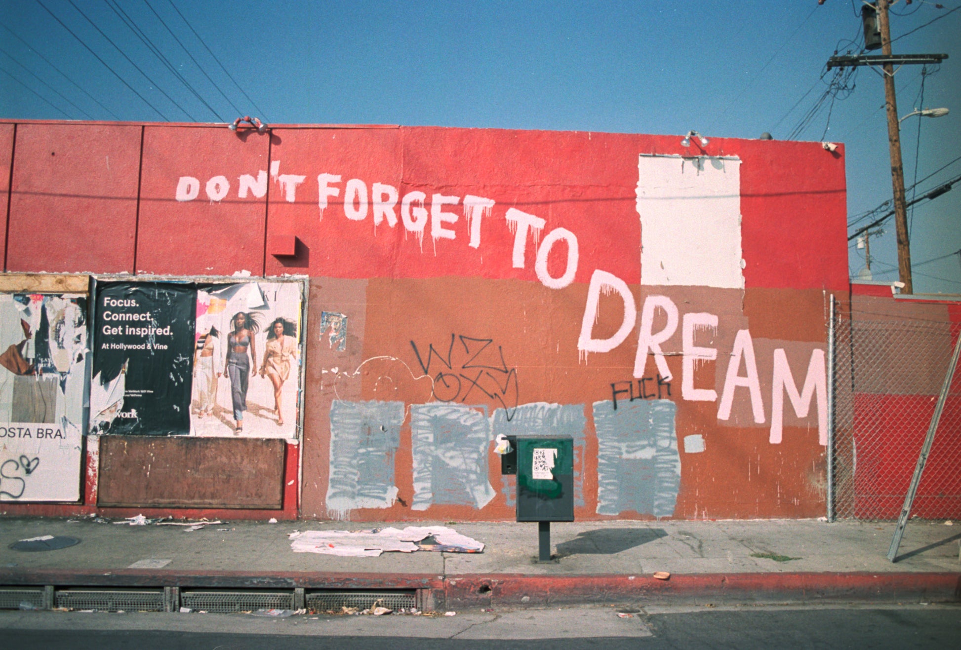photograph of side of building that is painted red and brown with the words "don't forget to dream"